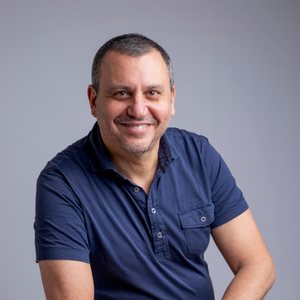 Portrait de Frédéric Myara, souriant, en polo bleu marine
