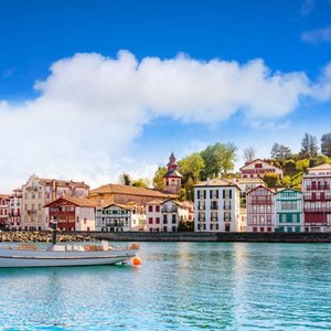 Maisons basques aux façades colorées au bord de l'eau, sous un ciel bleu